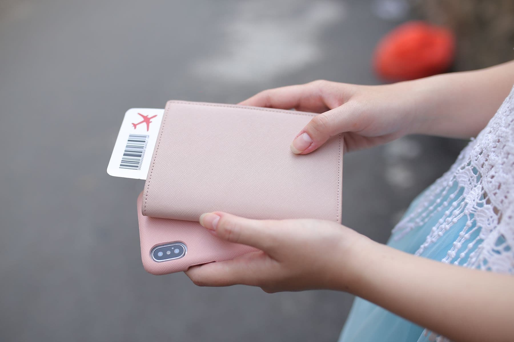 Traveler holding a phone, passport, and printed boarding pass