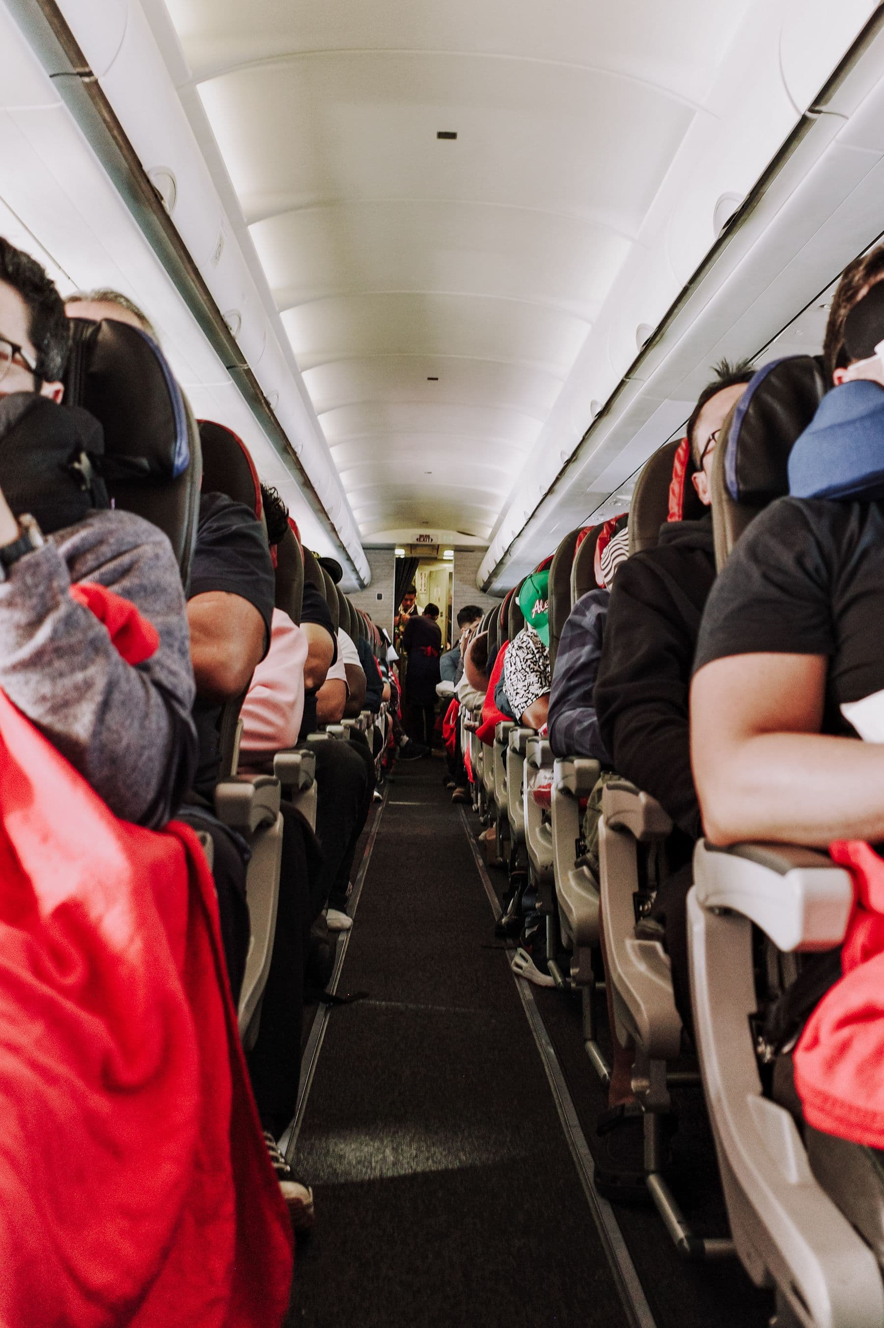 Passengers seated in a full economy-class aircraft cabin