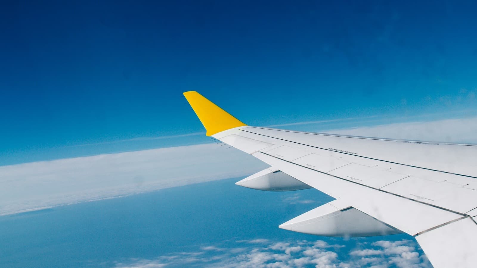 Airplane wing flying above clouds over the Atlantic toward Europe