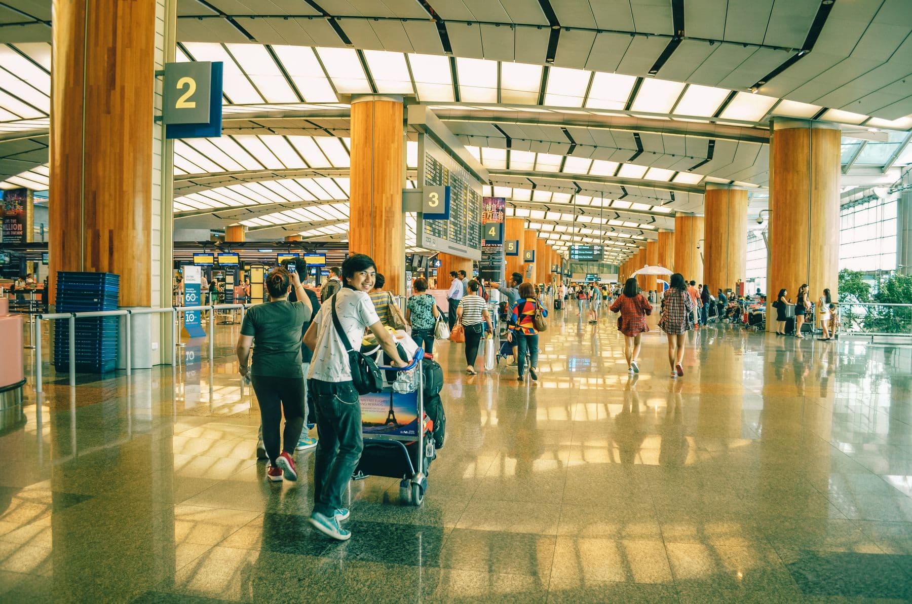 Travelers moving through Singapore Changi Airport terminal