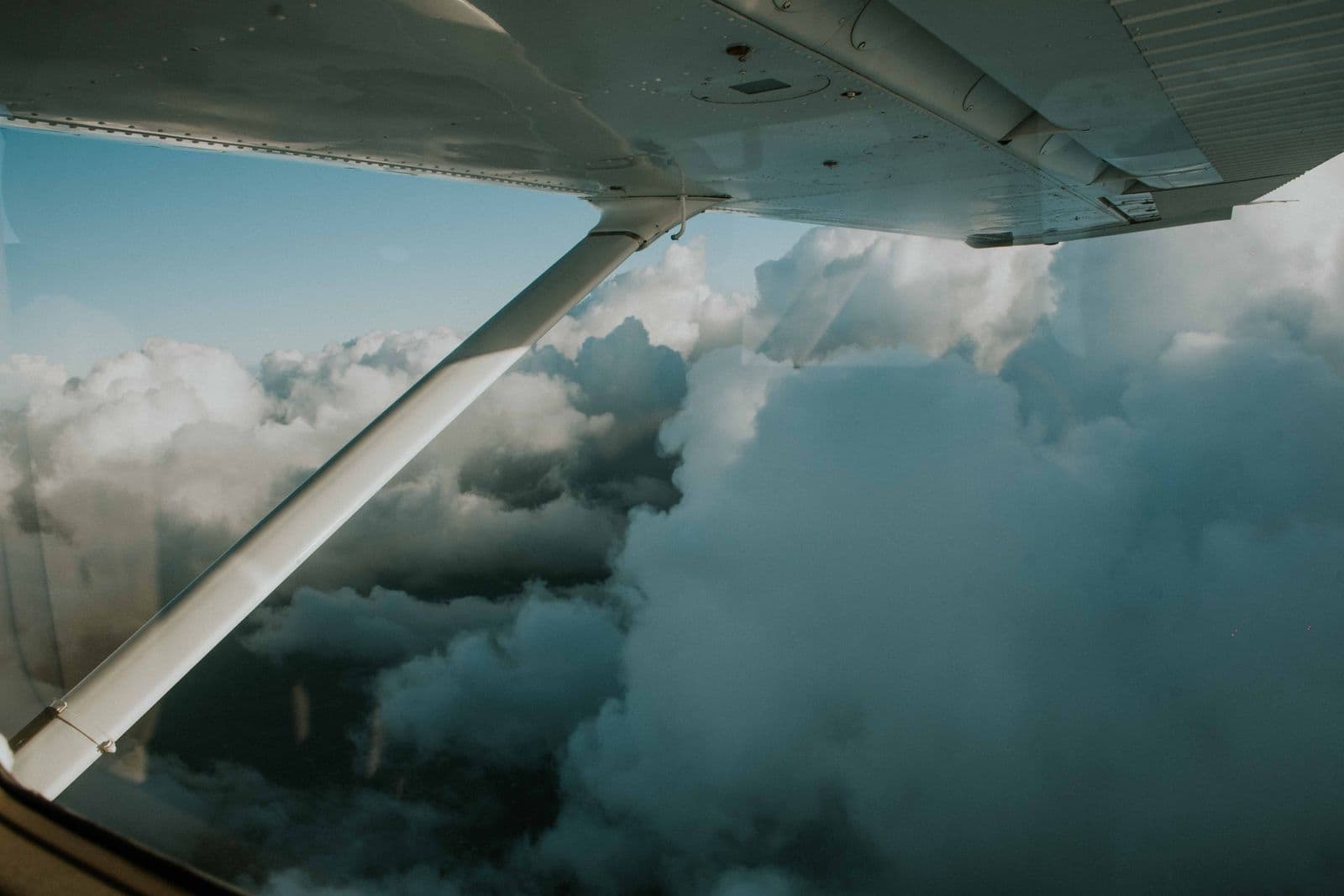 Airplane wing and clouds seen from a passenger window