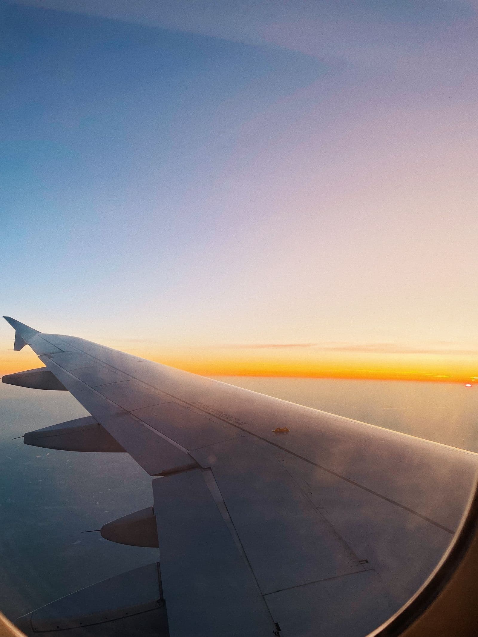 Airplane wing above bright clouds on an international flight