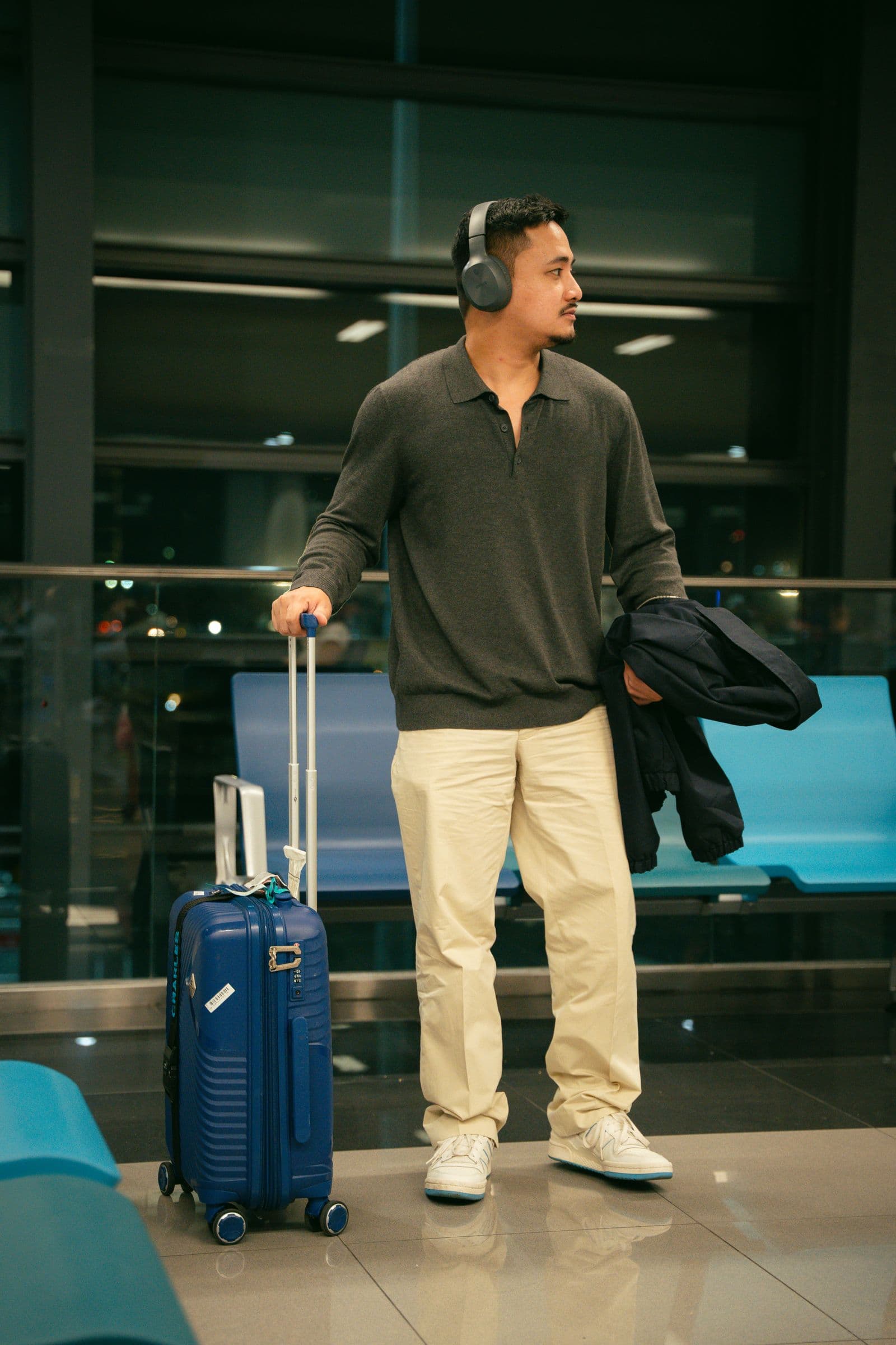 Traveler waiting with luggage in an airport terminal
