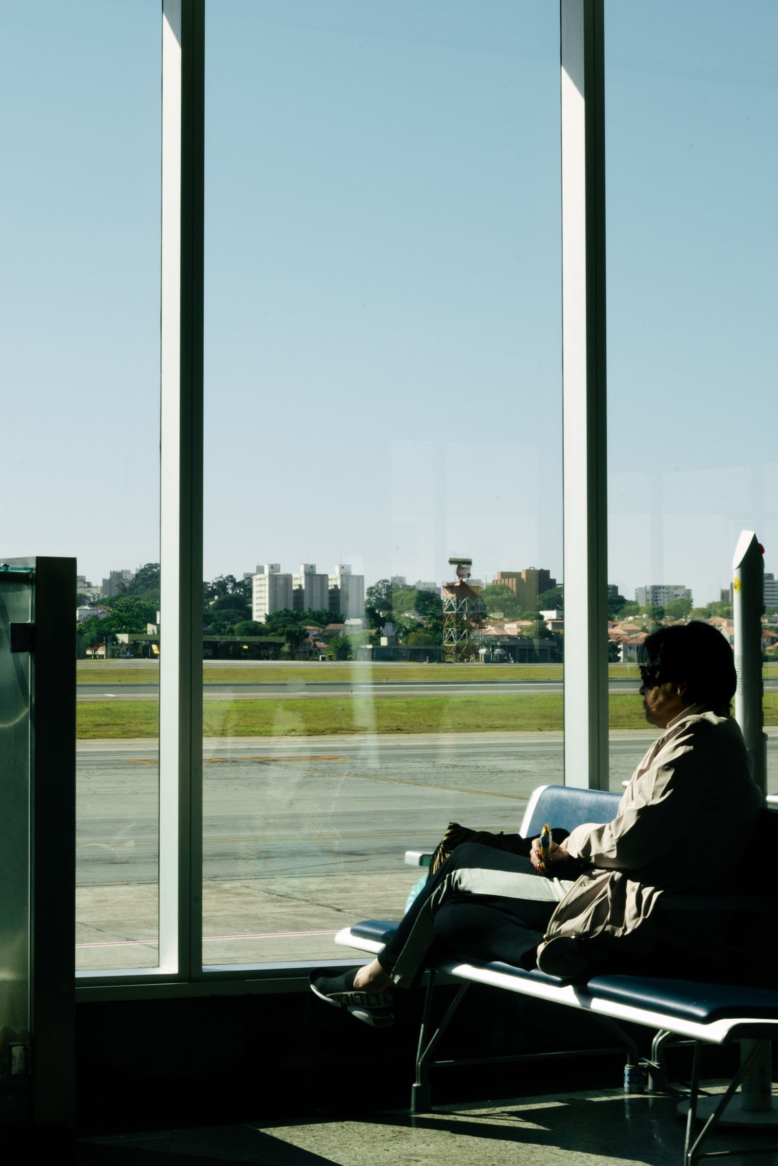 Traveler waiting in an airport terminal and looking out over the runway
