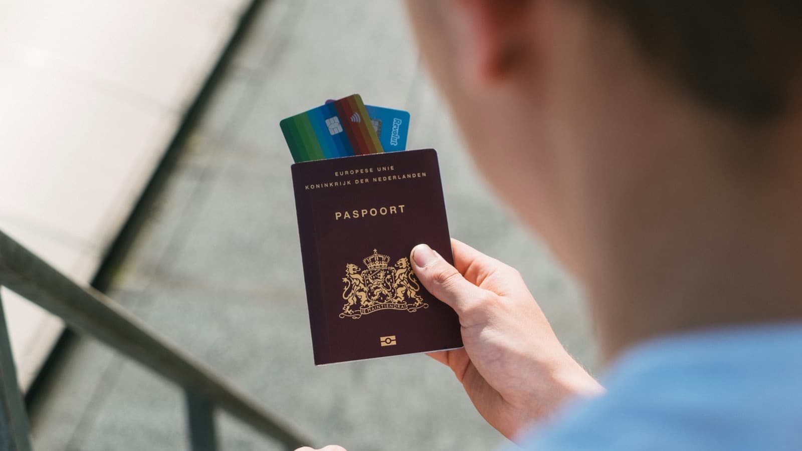 Traveler holding a passport with several payment cards tucked inside