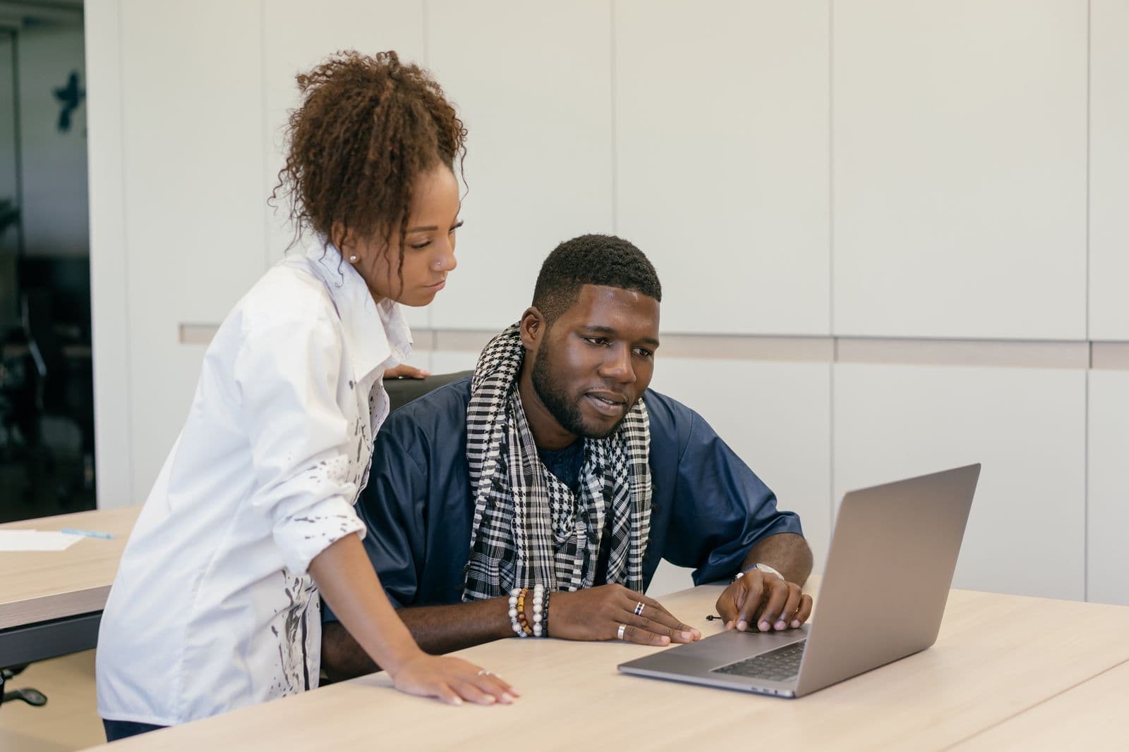 Travel consultants discussing options on a laptop
