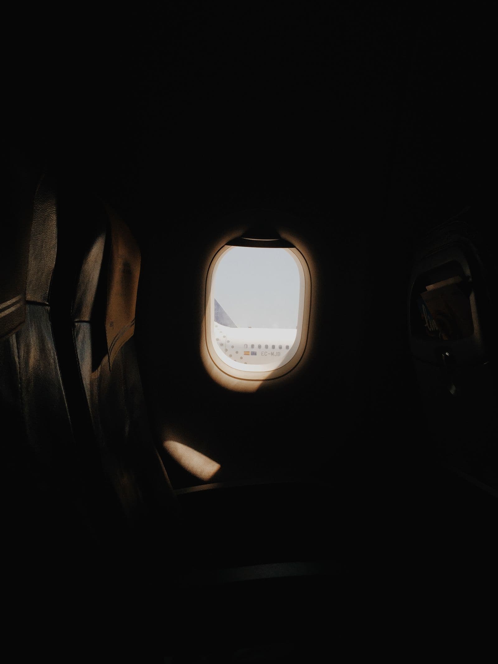 Airplane wing visible through a cabin window