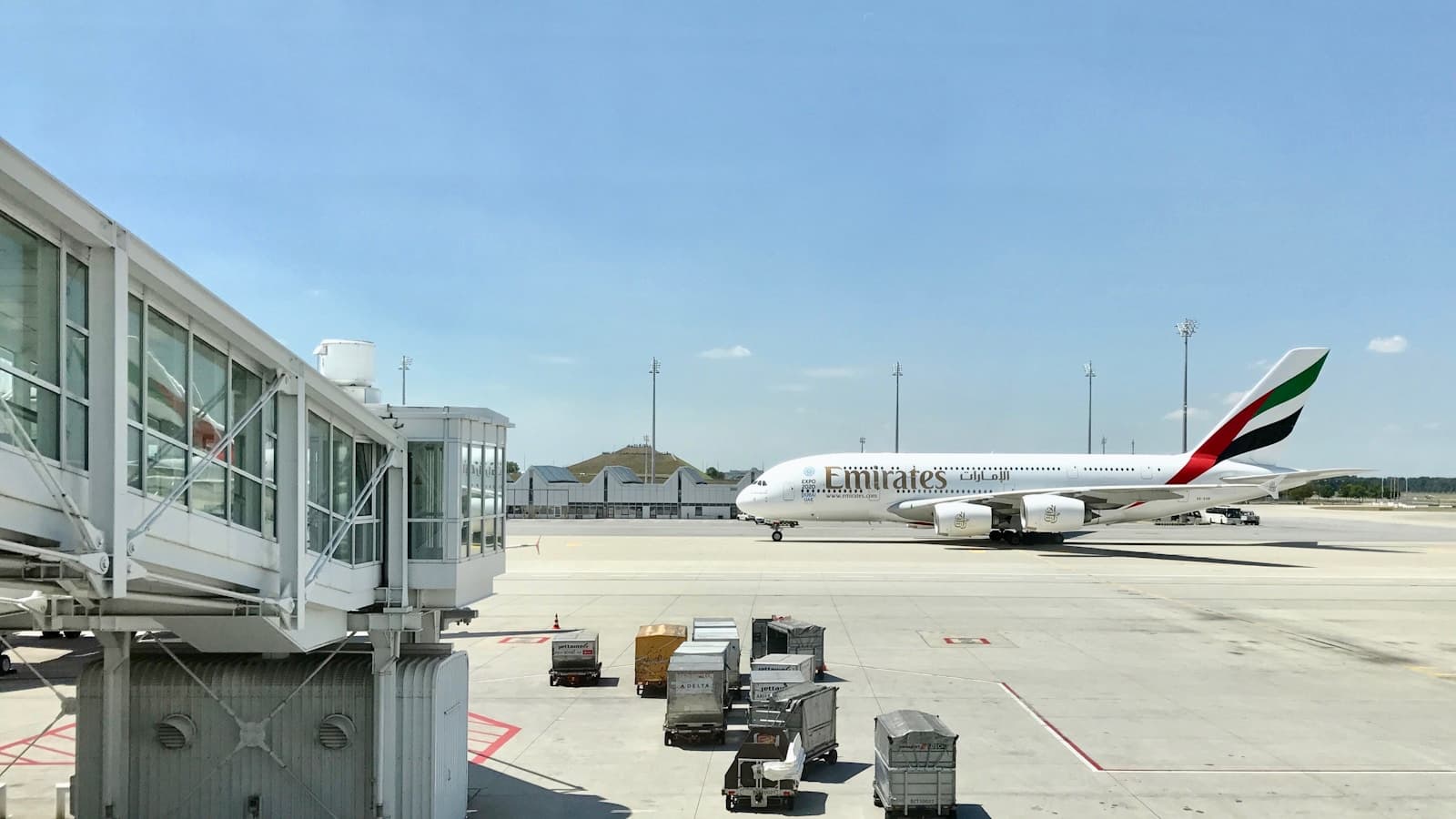 Real Emirates aircraft parked beyond an airport jet bridge