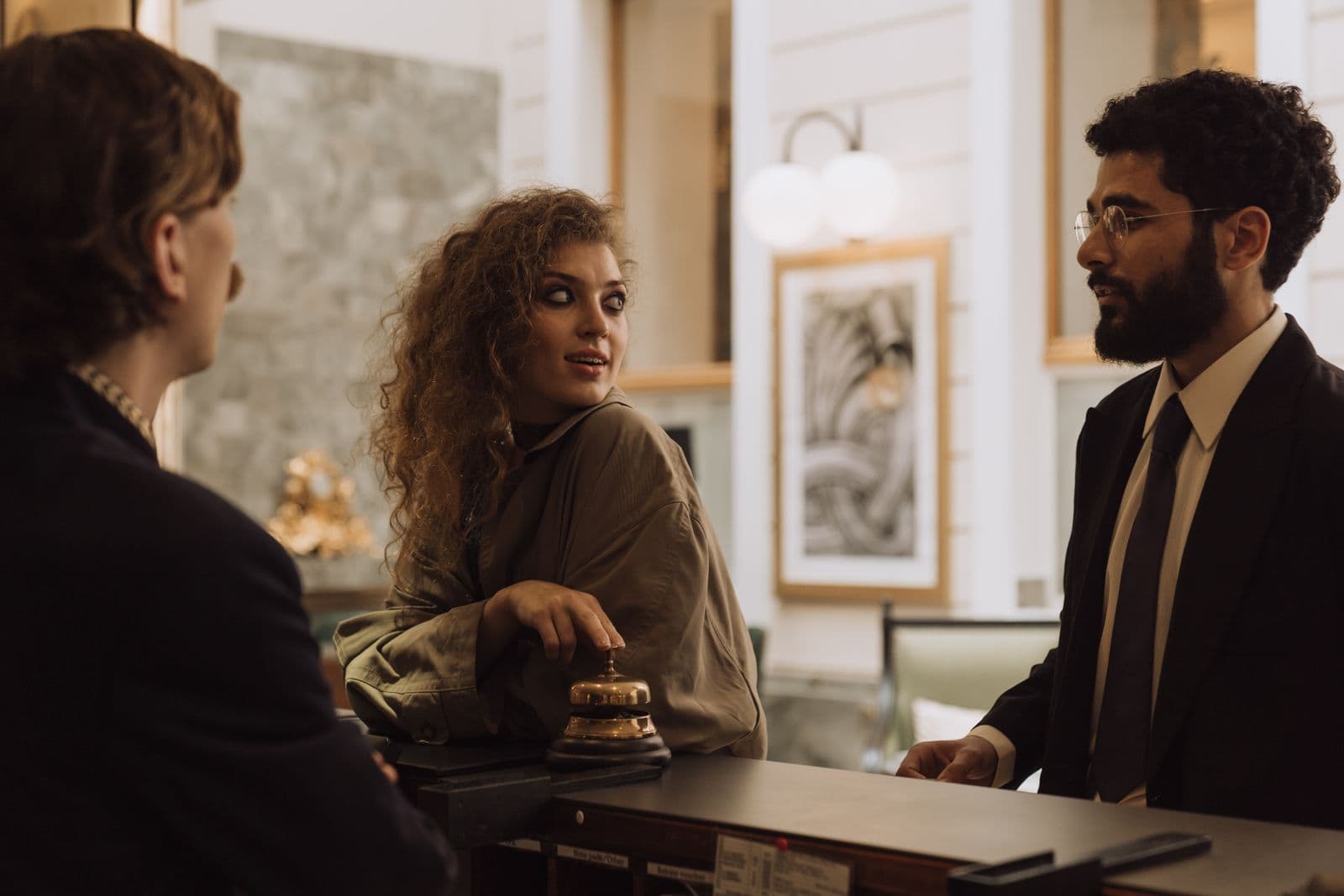 Guests speaking to a hotel receptionist across a front desk