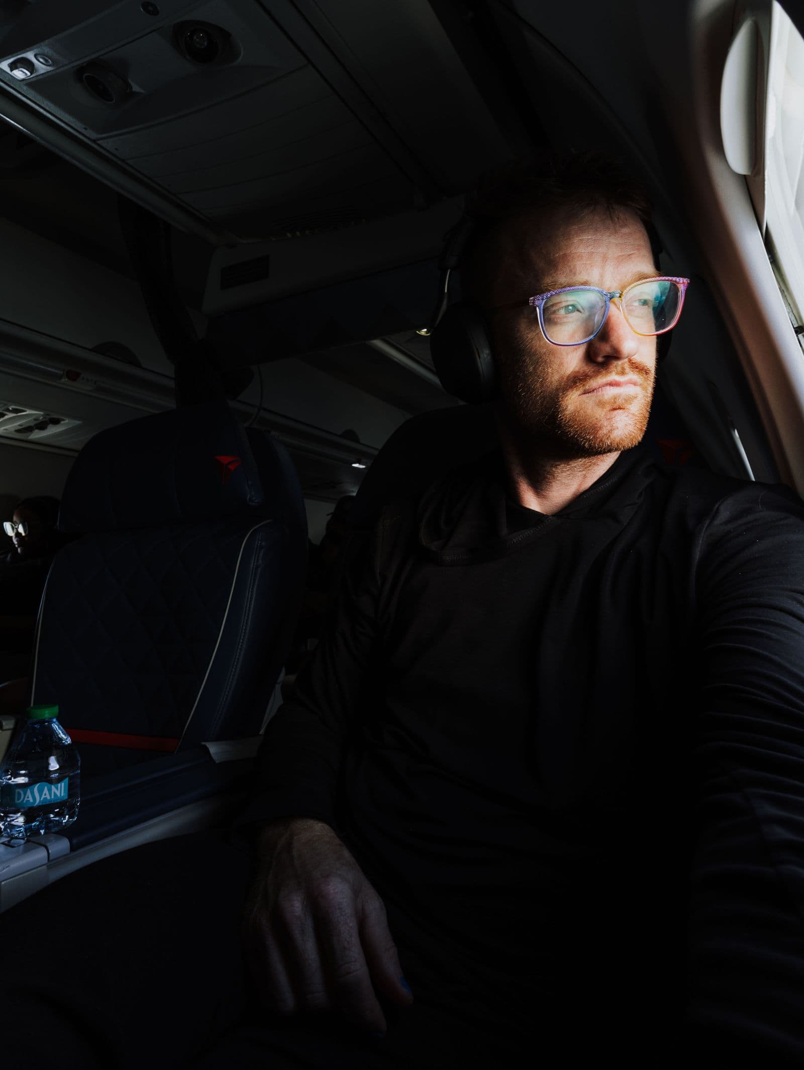 Traveler looking out an airplane window from a premium seat