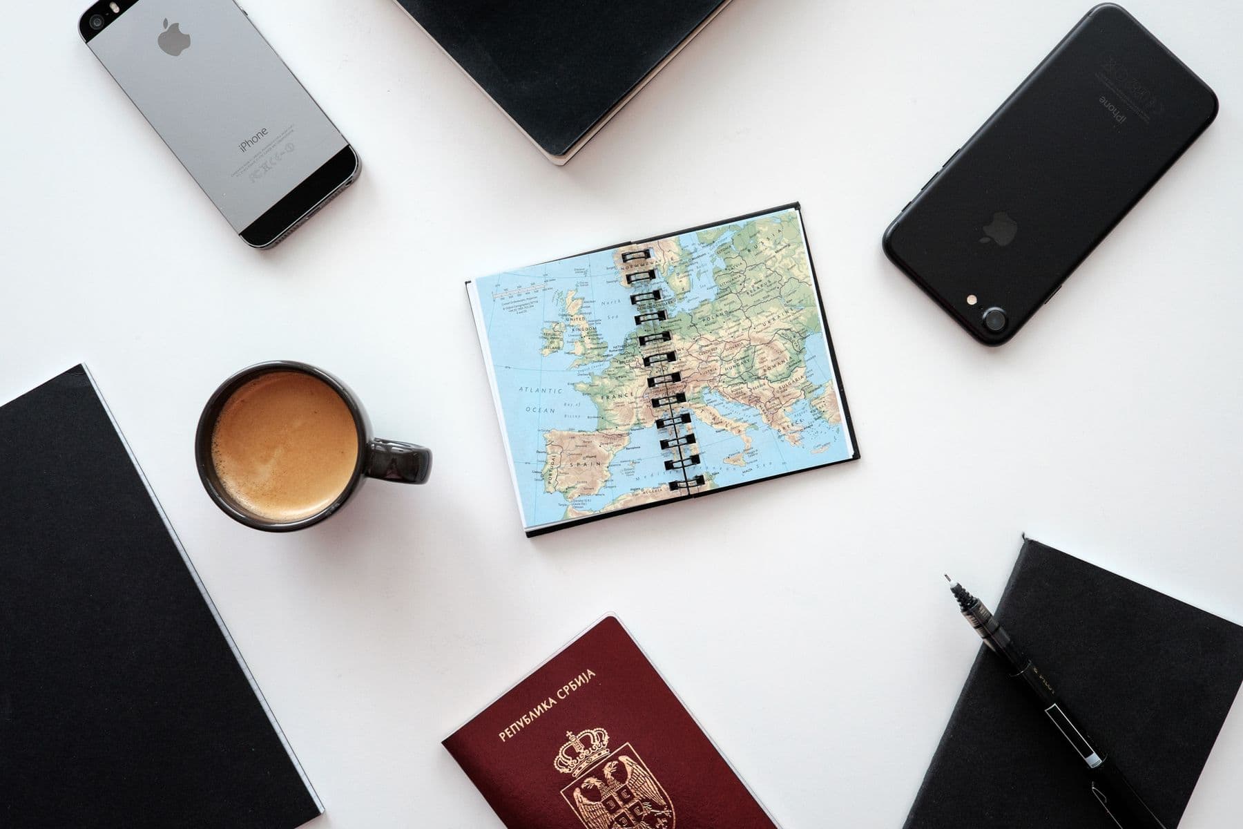Europe map, passport, phones, and notebook arranged for a multi-city trip