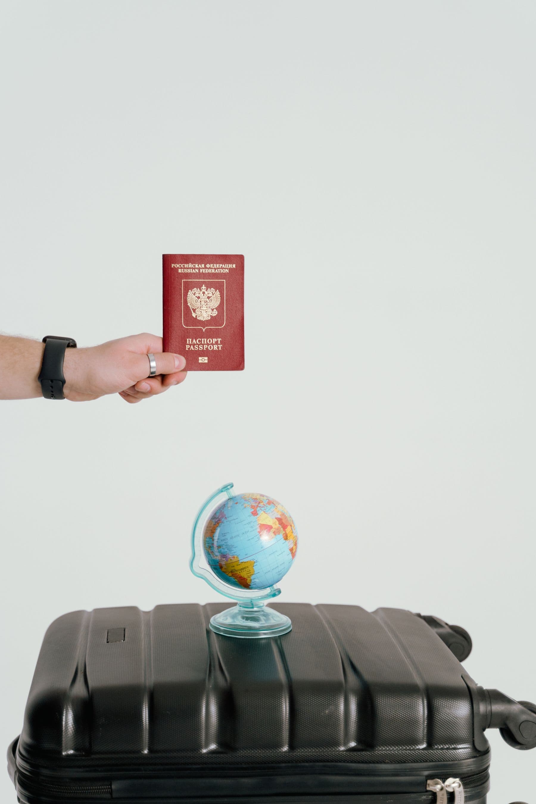 Small globe and passport resting on a suitcase